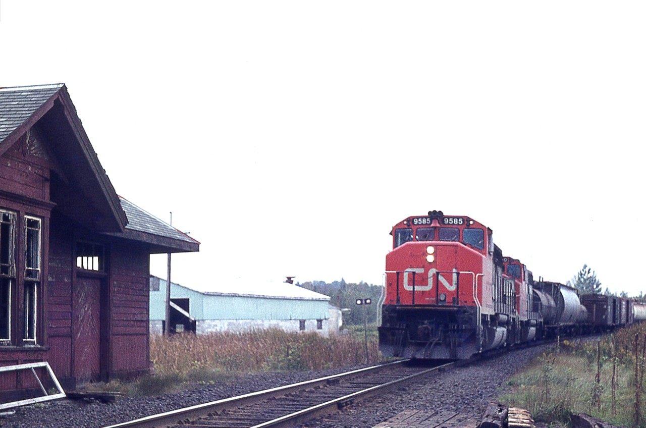 The old Mount Albert passenger station was closed to business in the mid 1960s. It was then converted to an office and meeting place for work crews along the line.  In 1977 it was moved to Cannington Community Center and is now preserved; strangely enough with Cannington namesigns and not Mount Albert.
It is a wonder the station survived. When I visited on this day it was thoroughly trashed by vandals over the years. Inside and out.  While I was there a northbound freight happened upon the scene, led by CN 9585. Nice to see the station was a survivor. You can see a bit on the left how much it had been damaged. It is a wonder it was not torched.
