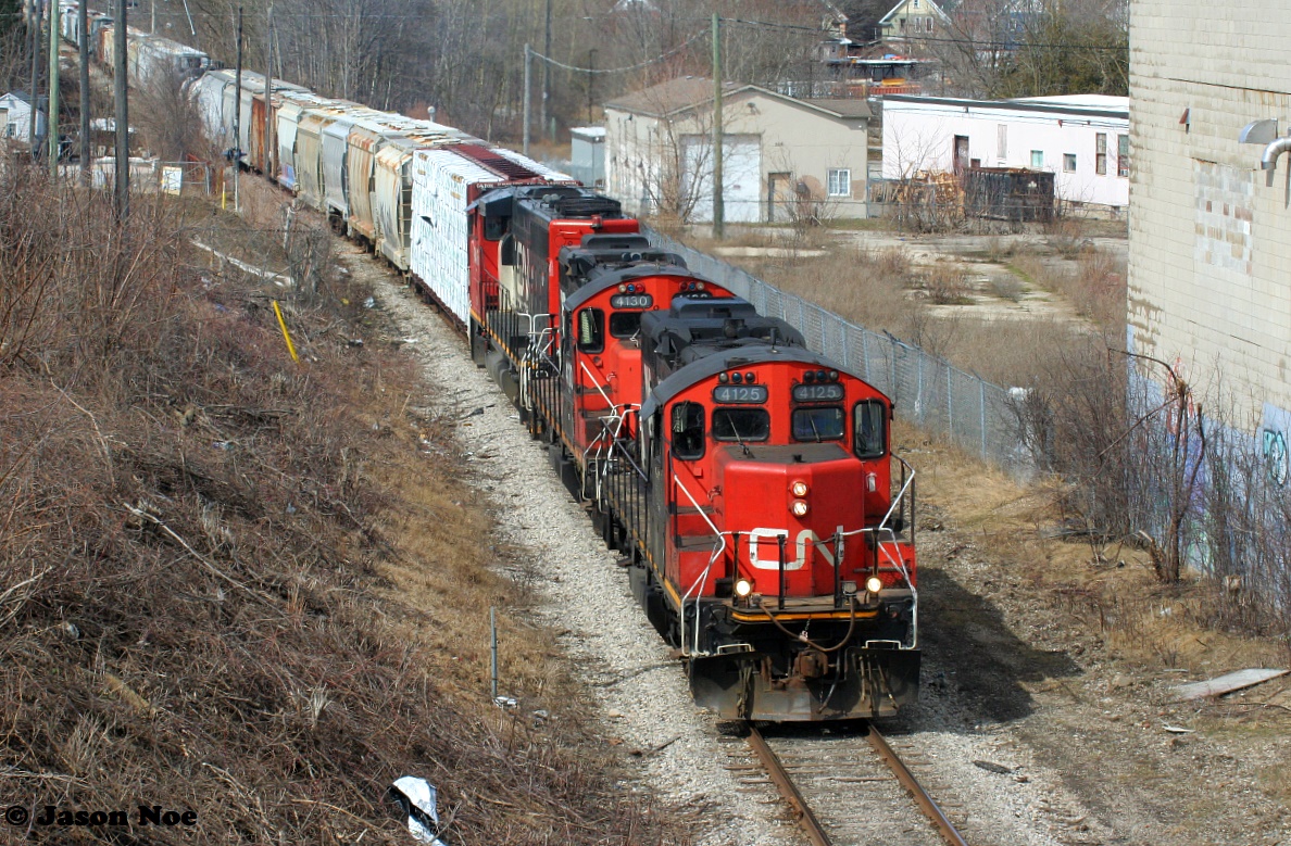 CN L568 with 4125, 4130 and 9416 leads a lengthy train as it heads down the Huron Park Spur approaching the Stirling Avenue bridge in Kitchener. The train was going to the interchange with Canadian Pacific at South Junction. March 20, 2022.