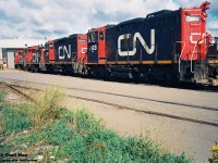 A Saturday morning in 1993 finds CN’s Stuart Street yard shop tracks full of units awaiting their next assignments. The units included from left to right were; SW1200RM’s 7103, 7104, 7307, 7314, GP9RM’s 4127, 4136, 4101, SD40-2(W)’s 5299 and 5310. Also, around the shop facility that day were SW1200RS’s 1355, 1369 and 1375. As well, SW1200RS’s 1359 and 1360 were observed switching the yard. I also have in my notes that there were five active CN cabooses around the yard; 79648, 79853, 79473, 79783 and 79482.

