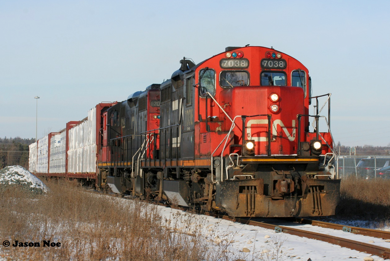 CN L542 with 7038 and 7081 are approaching Eagle Street North in Cambridge on the Galt Industrial Spur with cars for Gillies Lumber and Hunts Logistics. January 4, 2022.