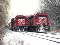 I decided to go for a wander to parts I probably would not go to now.......after all it IS trespassing these days. But back then, nah, you might get hollered at, but not likely.
I'm on the south side of the tracks just west of Kinnear office shooting the local with CP 3081 slowing to a stop when an eastbound (T.T. South) freight rolled up alongside.  Made for a nice image in the fresh white snow.
Power on the freight was CP 5502, 5684, 8205 and 5725. Was thinking this was train #270, which ran from Chicago thru to Binghamton NY via Southern Ontario around the mid '90s.