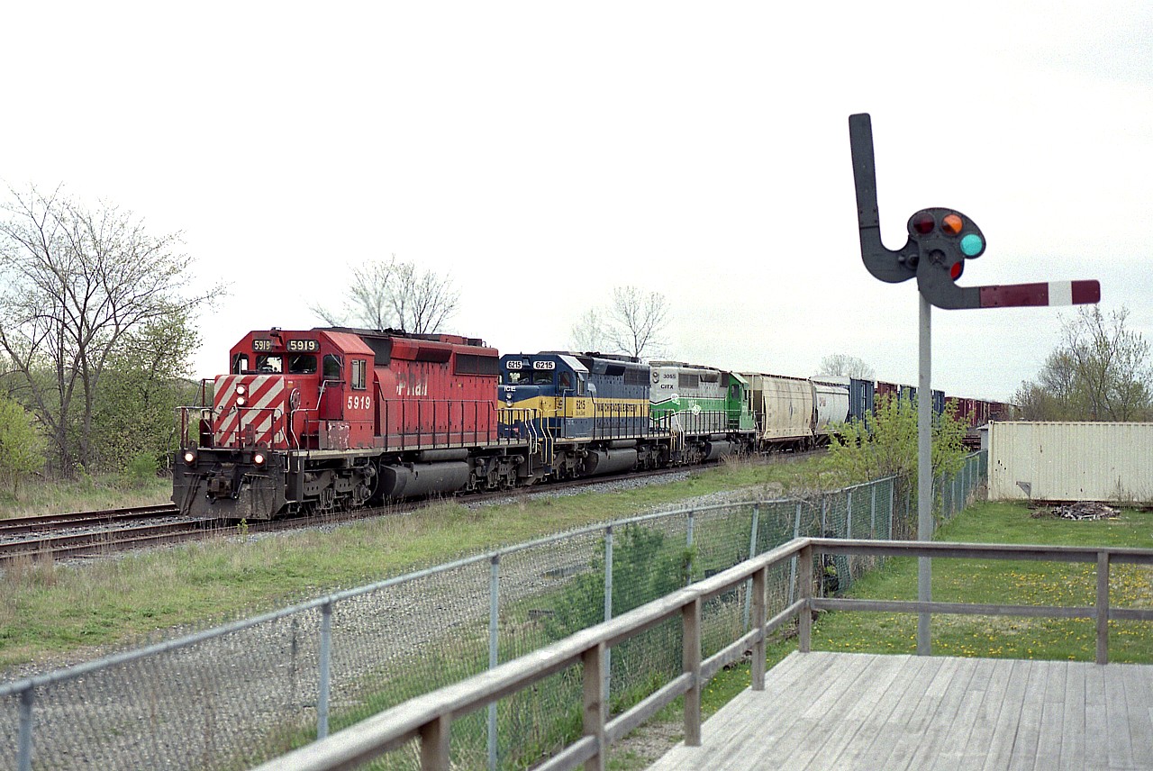 This is one of those places where I felt a bit of a different scene might help an image of the afternoon train heading west into Hamilton.  This is #255, and the time is around 1400 hrs.  I am on the porch of the old Smithville TH&B station. An alternative to shooting fields and trees. :o)
CP 5919, ICE 6215 and CITX 3055 is moving along smartly with a colourful consist typical of those days.  The last time I saw the CP 5919, it was working on Big Sky Rail out in Saskatchewan, having been acquired in 2020 from CP.