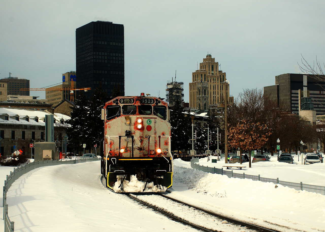 CN 9523 has an incredibly faded nose as it leads a short train of baretables out of the Port of Montreal.