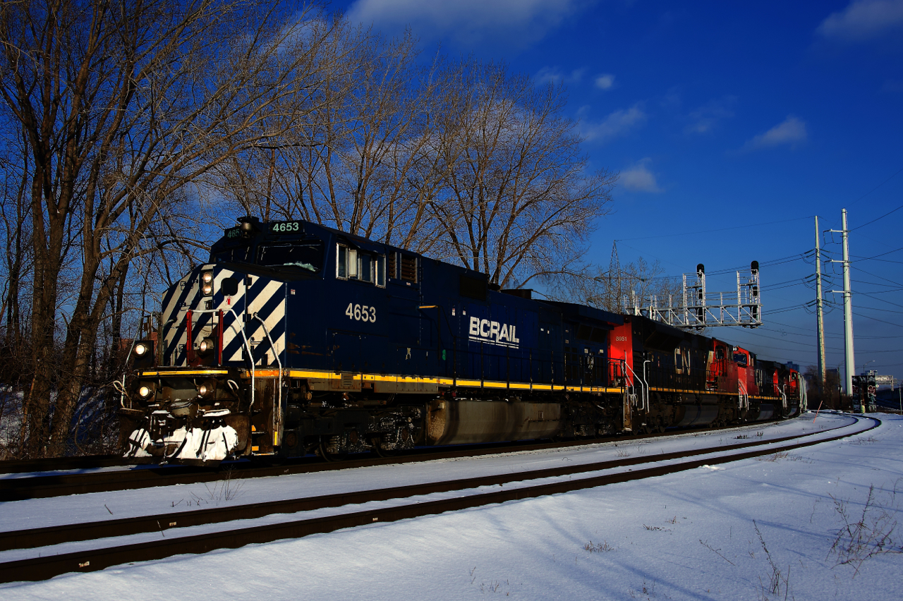 After setting off and then lifting cars in Pointe St-Charles Yard, CN 527 is advancing west on the Montreal Sub. Soon it will back up onto the rest of its train, which is on the Butler Spur (the track in the foreground). BCOL 4653 leads three more DC units.
