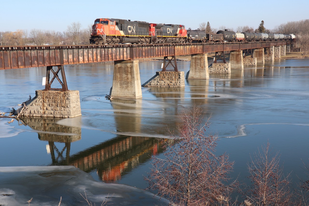 'Tis both scenic and peaceful as CN 502 trundles over the trestle and the iced, Grand River at Caledonia enroute to Three Fires and Garnet Yard.  CN 5654 and CN 2560 provide the power this day as the daily, morning freight snakes southbound along the Hagersville Subdivision originating Sarnia. A meaningful image for my 50th submission given my heritage and locale.