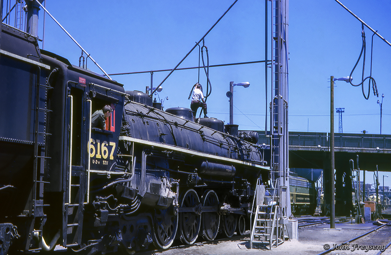 CNR 6167 pauses beneath the sand tower at Spadina on Friday, June 8, 1962 while being prepared for an excursion to South Parry taking place that Sunday, June 10.  Various GMD and MLW cab units can be seen in the distance, plus an SW1200RS.Scan and editing by Jacob Patterson.
