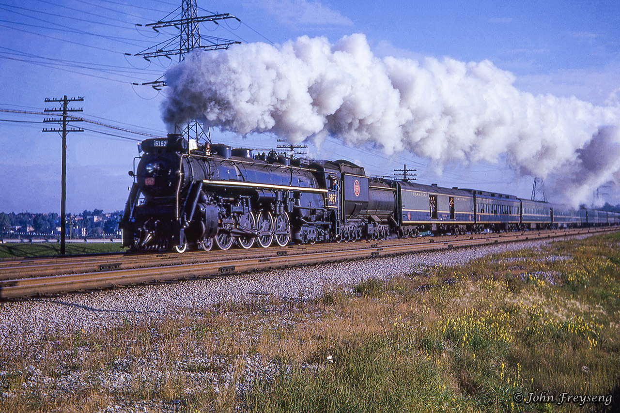 With a plume of smoke billowing above, CNR 6167 approaches the Humber River on its way west out of Toronto during an Upper Canada Railway Society excursion to St. Thomas.Originating at Toronto Union Station, the excursion ran to Hamilton where a pair of MLW RS3s; 3004, 3019, were added ahead of 6167 to assist the train up the Hagersville Subdivision to Caledonia, even though the 800 ton consist came in well under the 1,400 ton haulage capacity for Northerns up the grade. The diesels would be removed at Caledonia, the tender replenished with water, and the excursion would depart for Jarvis with a couple of runpasts along the way at Caledonia and Garnet, captured here by Bob Sandusky.  Further runpasts would be held along the Cayuga west of Jarvis before arriving at St. Thomas  where Doug Page captured the train  before it turned for home.Westbound over the bridge at New Sarum, Photographer Unknown.