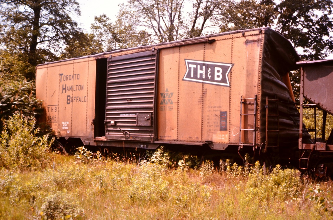 The 'Hold For Heavy Repairs' stencil says it all. TH&B box car 3645 appears to have been in an altercation and has suffered some damage to one end. It is now sitting at the former TH&B yard at Aberdeen Avenue in Hamilton, ON. Note the Canada Centennial logo to the right of the partially open door. A little sheet metal repair and some paint and this car will be hauling loads in no time. :-)