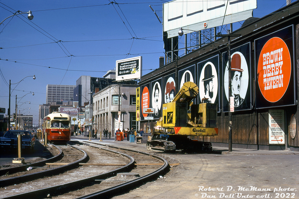 TTC PCC 4357 (A6-class, built by CC&F in 1947-48) ambles eastbound on Dundas Street past Yonge, through a track work construction zone and passing an old Gradall G1000 telescopic boom excavator. On the right is the Brown Derby Tavern, recently closed and soon to be rebuilt to house multiple retail outlets. Not sure what "Jugs and Mugs" in the "San Francisco Room" refers to, but it's likely something seedy, as were many establishments along Yonge Street back in the day.

Robert D. McMann photo, Dan Dell'Unto collection slide.