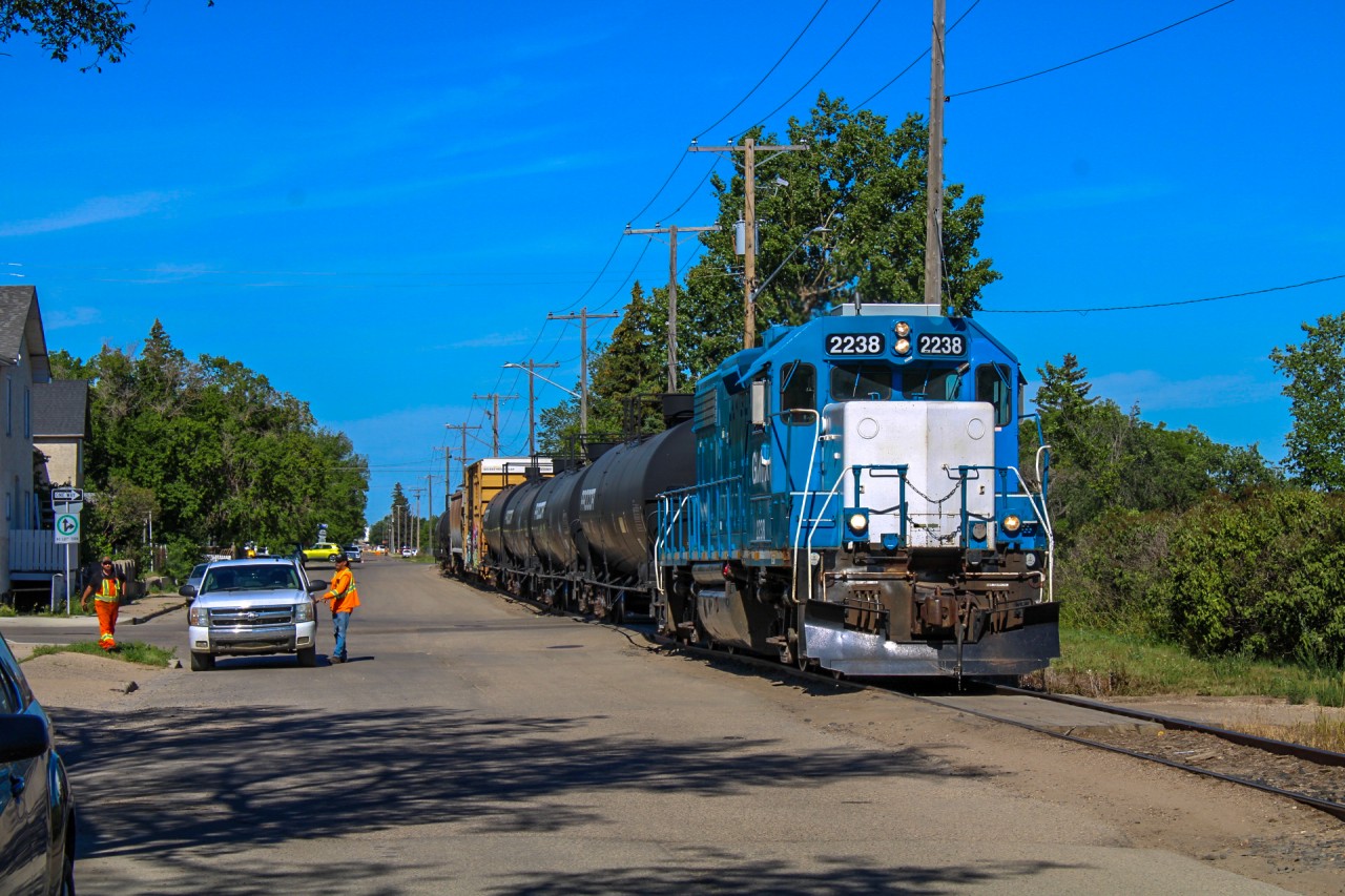 Over the summer, I had been itching to shoot the SRC movements on the scenic ex-CN Avonlea Subdivision, even if modern activity was a shell of the former power variety once seen on the trackage. I had initially camped out on the southeastern side of the valley in the hopes of capturing a scenic view of the CN Moose Jaw bridge but I drew an unlucky light power card so I got around to the street running portion of their transfer with CP. It apparently took me a while as I had just been pulling into Home Street when I could see 2238 rising upgrade around the corner, making me scramble to get my wide-angle lens out in time. To the left, a crew in a work truck escorted the local towards the junction with the Avonlea, and manually protected each roadway the tracks intersected with. Prior to their departure towards Truax, I had a fun chat with both crews and would, unfortunately, have to decline the temptation of a chase as I had to be back in Regina for a shift at my summer job.