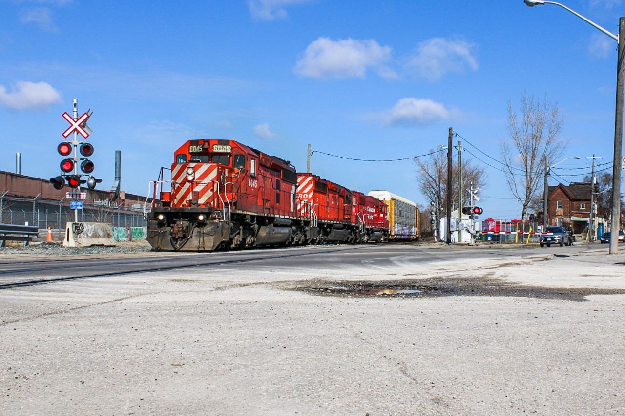 Streetrunning? Not quite, although CP H17-27 mimicked such a scene when it crawled through the shallow-angled Old Weston crossing where one could capture the awaiting road traffic in the frame with ease. RTC, West Tower and the crew onboard 6045 were at this point hurrying to get the train into the yard before the crew's 12 hours were up, but decision making was time consuming enough that H17 slowed down to wait for instructions. At the moment this photo was taken, they only had 10 minutes remaining on the clock, and the straw that broke the camel's back was a failure by West Tower to notify RTC of a last minute change to the track H17 was lined into, and so they took the light onto the incorrect track and had to come to a stop until the clock ran out. They would block the crossing for about 90 minutes until H19 was ordered to rescue and subsequently use this consist eastbound. Before heading home, I would notify some of the drivers about the situation and advised them to take a detour. Among these included an unfortunate fellow (waiting second in line just to the right of the silver car in image) who was driving his motorbike to Cyclewerx just 1 block on the other side of Old Weston for repairs for a faulty start-up, and figured taking the risk of turning off his bike was worthwhile given the short distance. It was only once I told him that H17 was out of hours that this decision would become regretful as he couldn't get it to start up again. I'm unsure if he waited the full 90 minutes or if he pushed his bike for the 1.5 km detour to the shop (compared to 280 m direct). Part of me hopes he figured a way to get it started after I left.