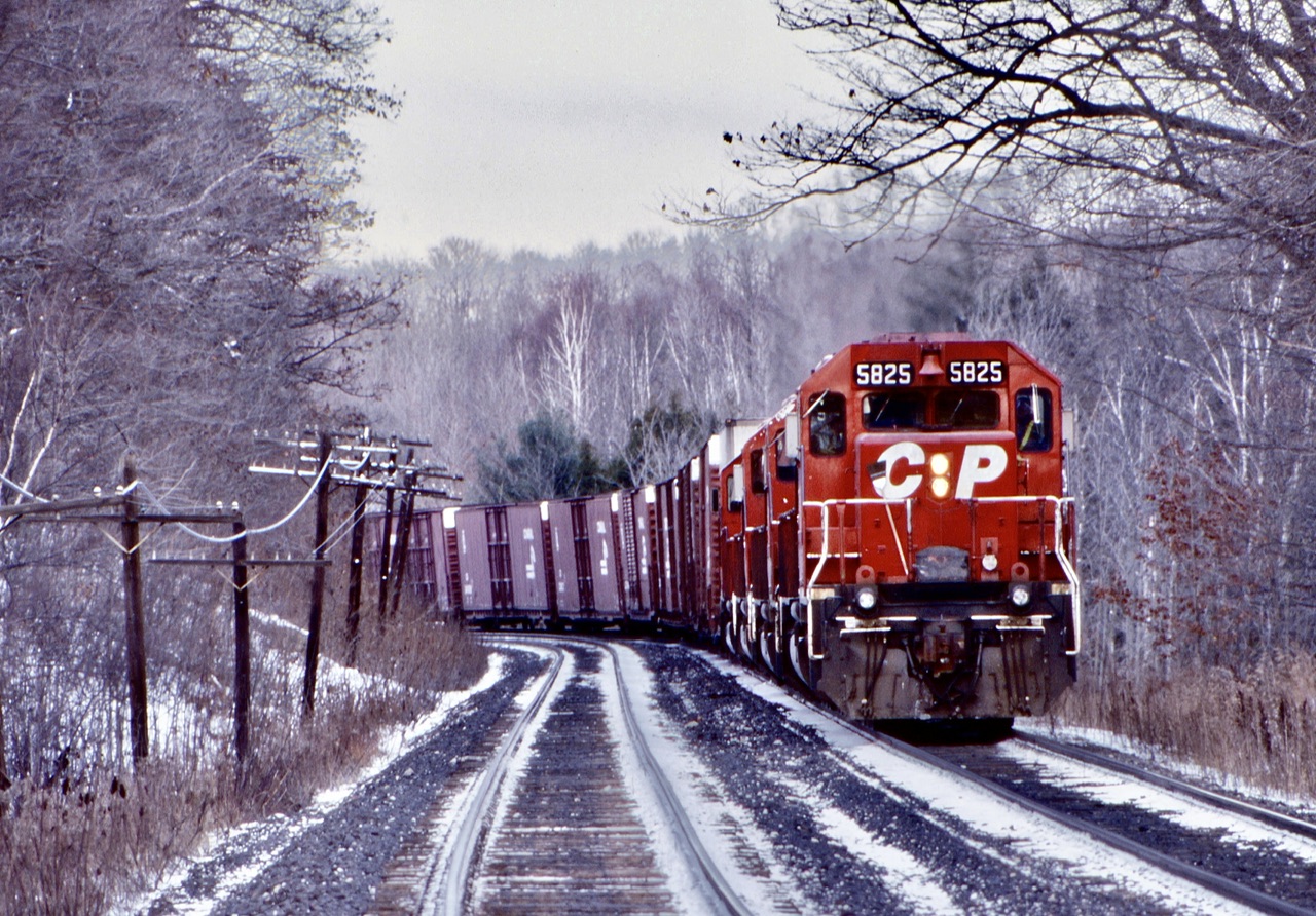 A winter shot for a winters day. This day a westbound train with four SD40’s was being held near Guelph Line, waiting for a higher priority train to pass on the north track. A little bit of autumn foliage still clings to the trees. Nice to see a once so common cut of Conrail auto parts cars. How times have changed.