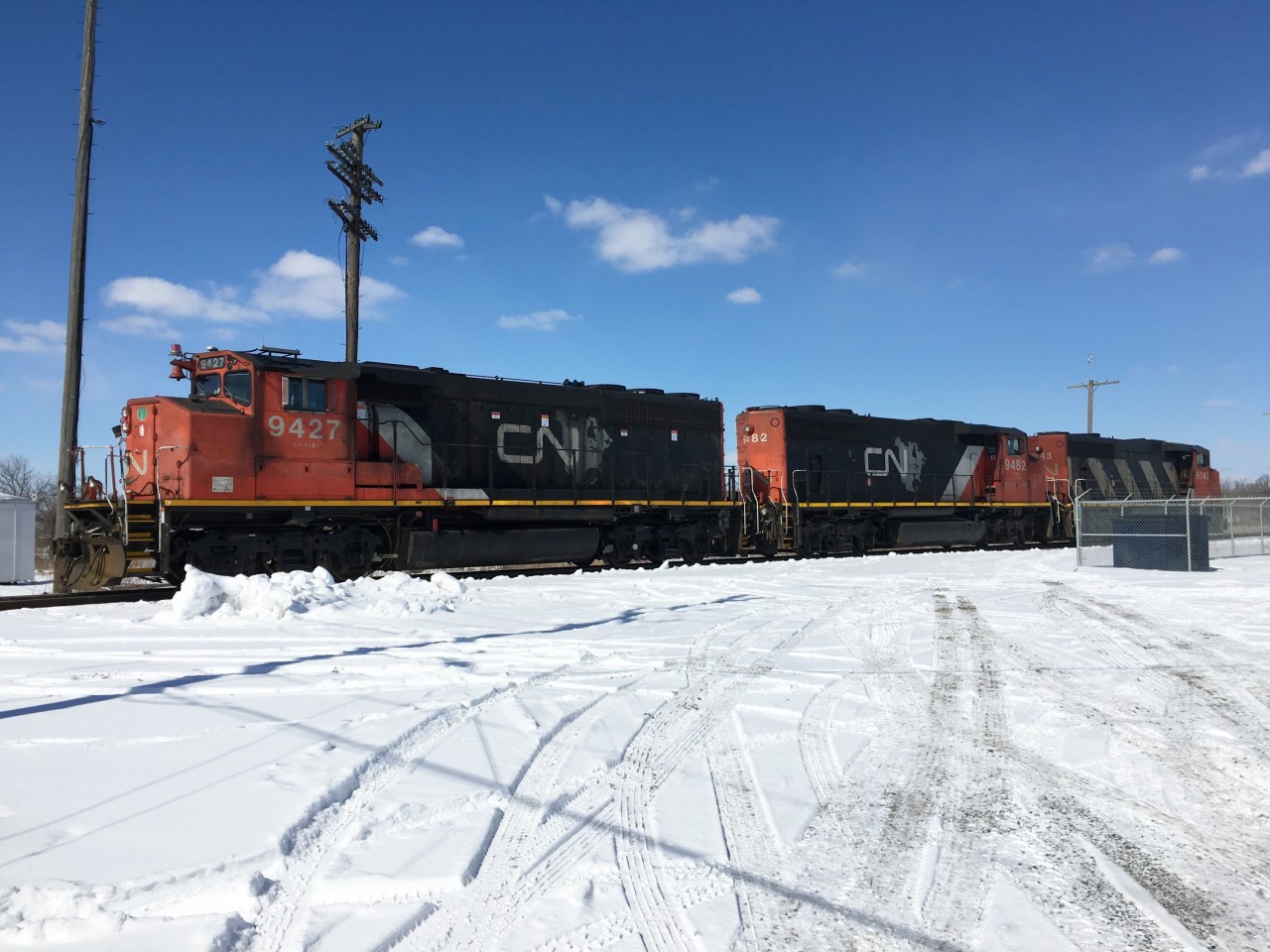 It's lunchtime at Hagersville as a trio of CN locomotives sit idling near the new Operations trailers. A pair of North American maps and a line of zebra stripes on this power splits the snow covered ground and the clear blue sky nicely on this cold, clear day.