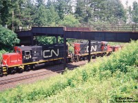 CN 562 with GP9RM’s 7036 and 7035 head west under the original Inksetter Road bridge at Copetown, Ontario on the Dundas Subdivision. At the time, this local originated at Hamilton’s Stuart Street Yard and would often head west to the Paris pit during Sunday’s. Caboose 79707 was on the tail-end on this day. 
