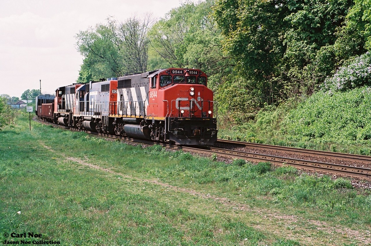 A CN eastbound with GP40-2L(W) 9544, a GTW GP38-2 and another CN GP40-2L(W) is viewed curving through the town of Paris approaching the John Avenue overpass as it heads to Hamilton on the CN Dundas Subdivision.