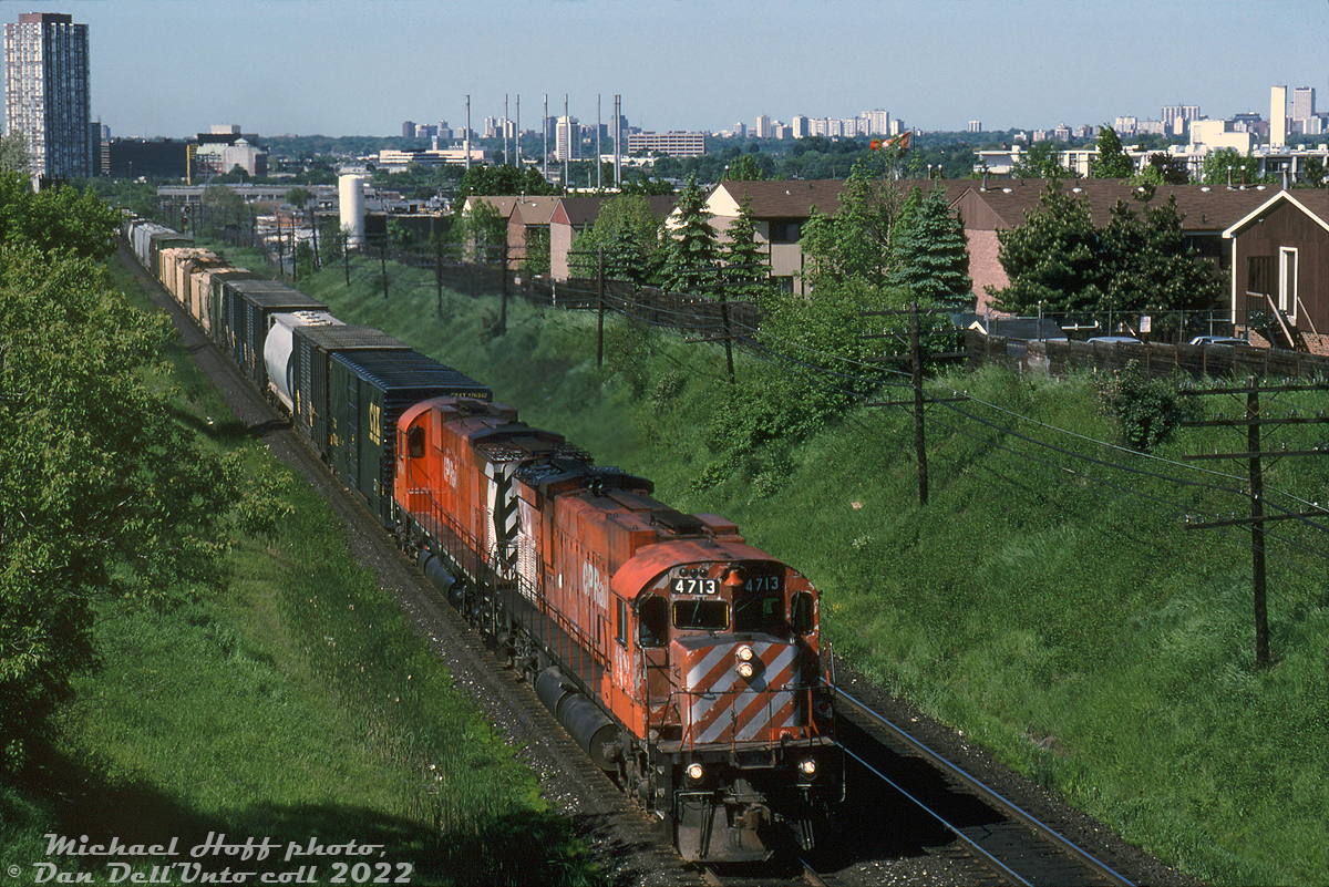 A pair of well-worn 6-axle "Big M's", lead by ratty looking CP M636 4713, head eastbound across CP's Belleville Sub approaching the Victoria Park Avenue overpass on their way to Agincourt Yard. The midtown Toronto skyline is visible in the background, with numerous hi-rise apartment buildings and office towers including the Inn on the Park hotel tower near Don Mills.

By this time CP's "Big M's" were on their last legs, and retirement for the last ones wasn't far off (the official Big M retirement would be held at St. Luc later that year in December). A handful had one last hurrah when they were pulled for the deadlines and reactivated for a year or two due to CP's chronic power shortage issues. CP 4713 would be retired in December 1993, reactivated in April 1994 but only run for just two months before being sidelined for good.

Michael Hoff photo, Dan Dell'Unto collection slide.