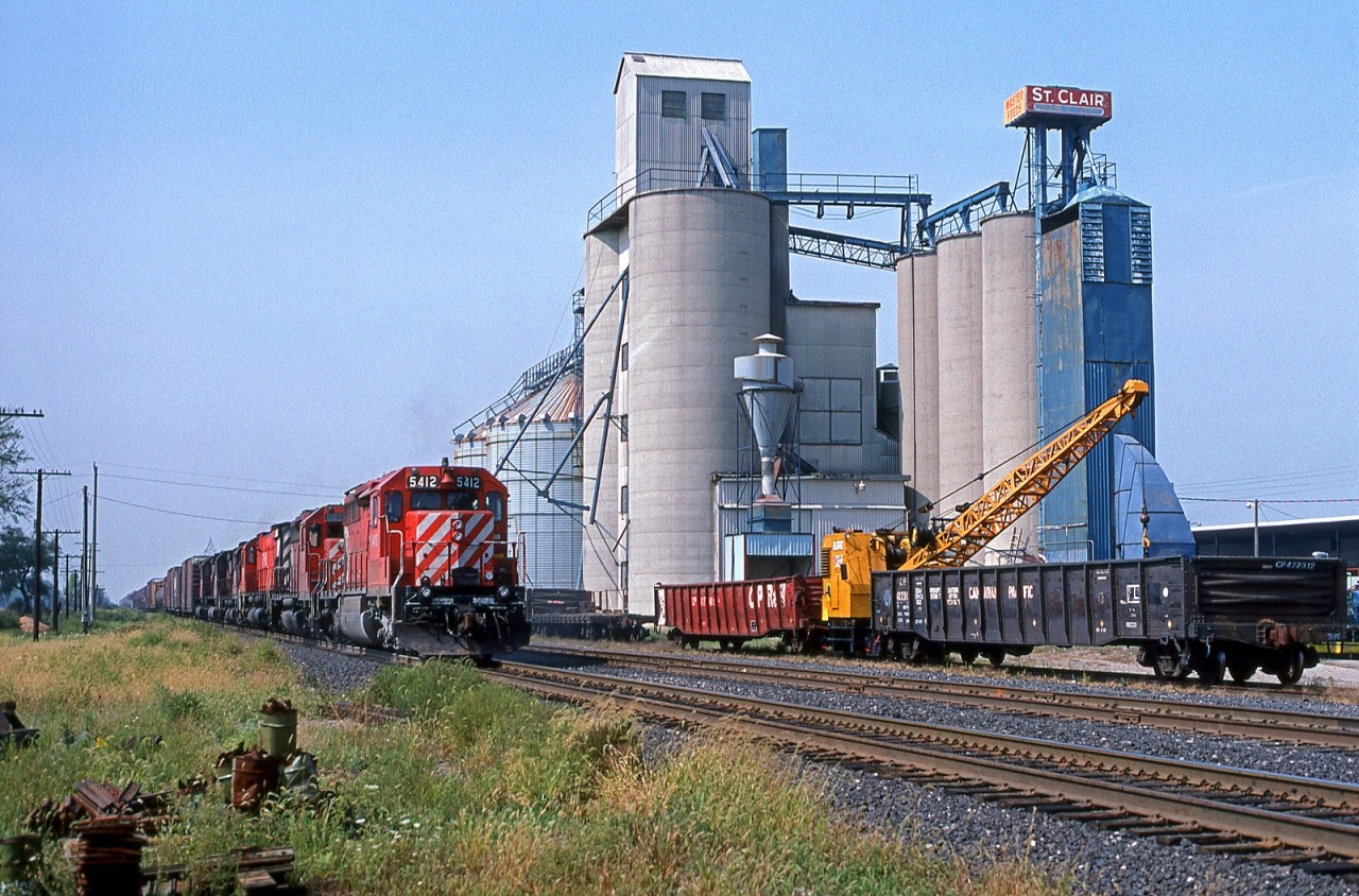 A raft of CP power lead by the 5412, has train 904 in hand as they pass the mill at mile 80 on the Windsor Sub, Tilbury Ontario 09/18/1988.The mill is long gone.