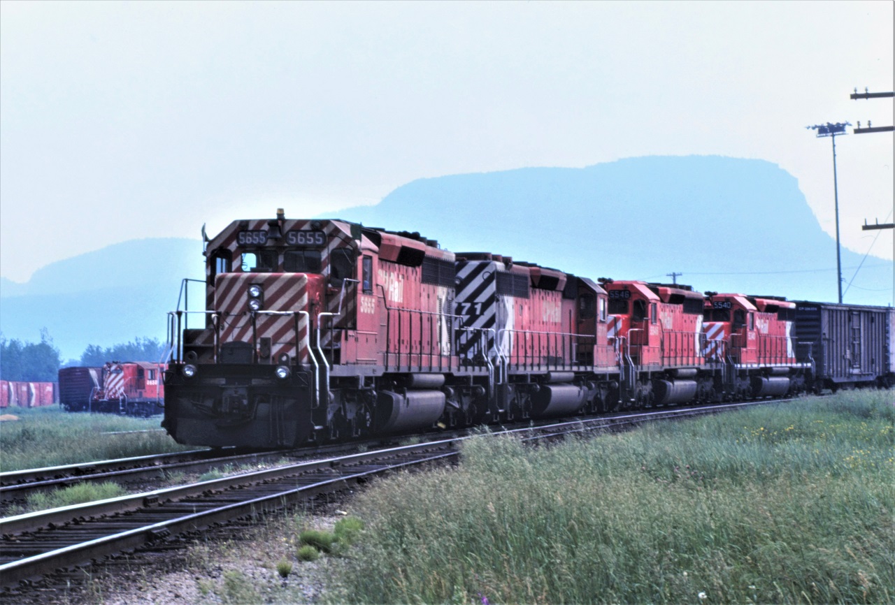 Smoke hangs heavy from early season forest fires in Thunder Bay, Ontario on June 26, 1980, as the first section of an eastbound train arrives behind a pair of SD40-2s and a pair of SD40s.  5655 leads the 5771, 5546, and 5540.  Location show is a guestimate as my memory does not go back that far!!