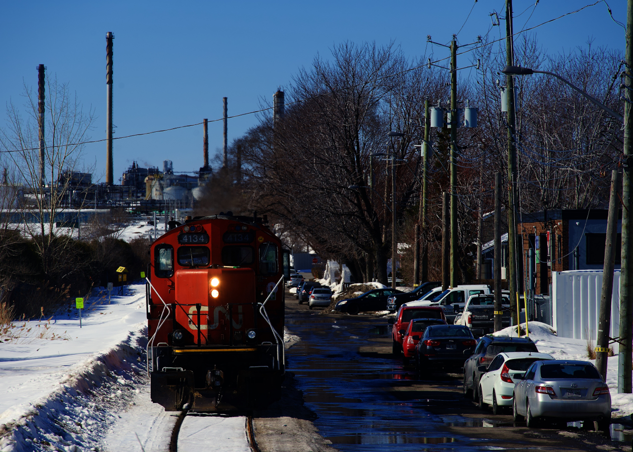 The Montreal East Switcher is heading light power to pick up empties at Bitumar. This spur closely parallels a residential street.