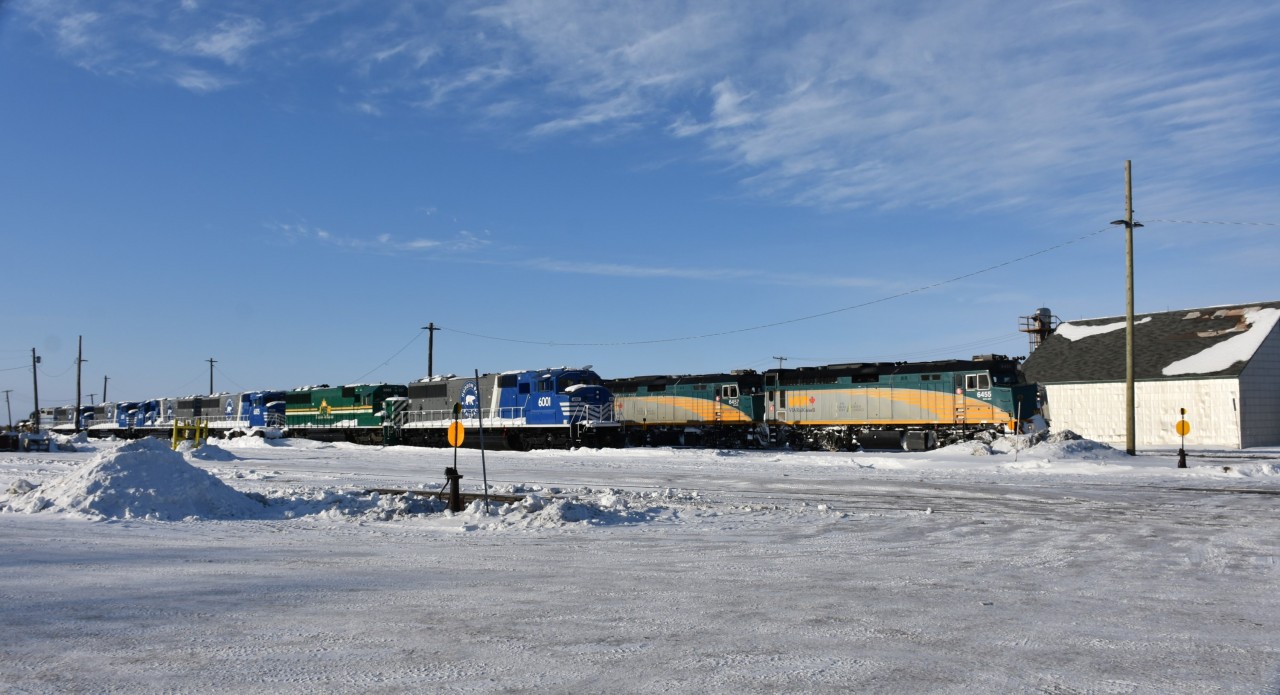 VIA 690 has wyed its train and is gliding past the Hudson Bay Railway engine terminal and yard in The Pas, MB on another beautiful but frigid morning. I have yet to count all the different HBR locomotives I captured during my two-day stay in The Pas but the number is around twenty! On this storage track next to the mainline, a rather new HBRY 6001 leads a line of new and old HBR power that is all shut down, and waiting for their turn to go to work. To the left of the frame is the diesel shop, roundhouse, & shop tracks, and behind me is the HBR H.Q. office building.