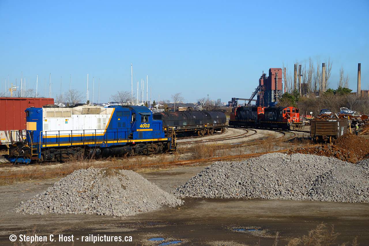 With Stelco looming in the background, the Hamilton yard 0800 job is about to lift gondolas from Sunrise metals while RLK 4003 waits for it's next role. Parked after the Southern Ontario Railway lost their lease in December 2018, 4003 would be re-activated by the Lambton Diesel Services folks in 2022 and is now painted for GIO Rail. (Mooney)