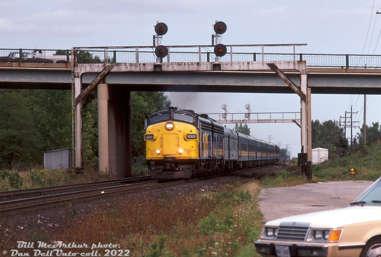 VIA FP9 6510 and F9B 6614 haul train #73 westbound on the Oakville Sub through Aldershot, passing under the signalbridges at Waterdown Road. An ex-CP baggage-dorm trails the power, followed by eight of VIA's ex-CN blue & yellow fleet. 

After retirement, VIA 6510, the only CN/VIA FP9 with its bell mounted on the right side (above the engineer) was donated to the City of Thunder Bay and is currently on display at Kaministiquia River Heritage Park. VIA 6614 became Algoma Central 1762.

Bill McArthur photo, Dan Dell'Unto collection slide.