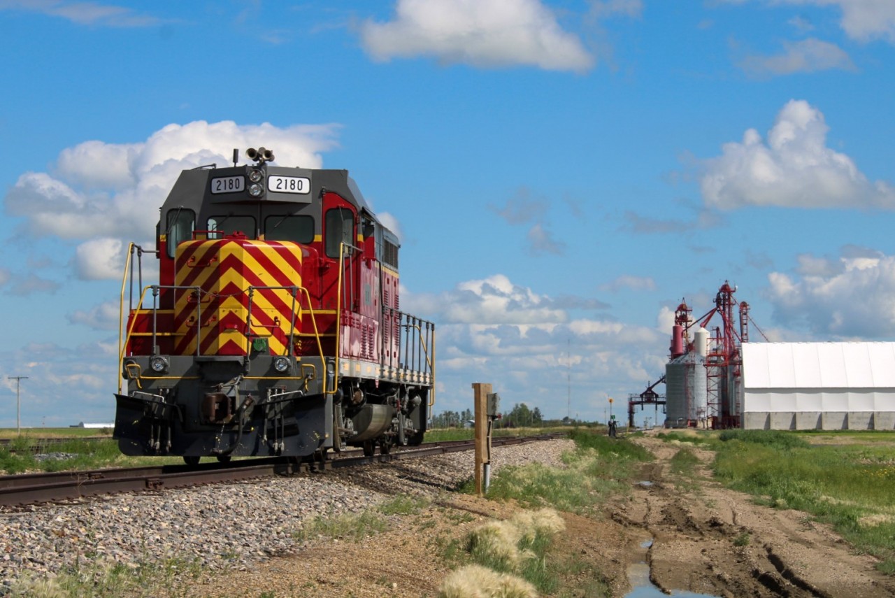 (Skip to paragraph 2 to read about the locomotive)  During the summer I had been making some intensive cycling excursions to the Weyburn Subdivision from Regina when my ride wasn't available for the week. I road biked 55km on the first excursion to Milestone which yielded 8781 S on 148 (  http://www.railpictures.ca/?attachment_id=50222  ) which led to a scare on the ride home when my rear tire burst. Fortunately a friend of mine picked me up that day after I lugged my bike 4km in the 32º heat to the nearest town. This time round I came overprepared and my backpack was filled with spare water bottles, tire tubes and bike repair equipment, which almost worried me about a self-fulfilling prophecy situation in which the extra weight risked another burst. Fortunately no such outcome came to fruition and I was able to complete the full 100km ride round trip. Having no space to pack a lunch that day I made a calorie-heavy stop at Canadian Superstore on the way home.

 If you know any retired guys from Louisiana in the 90s, MRI 2180 may induce some nostalgia in them, having been built as a GP7 for ATSF, and spending some time in the hands of New Orleans and Lower Coast Railroad around then. A crew who used to run the unit reached out to me on Facebook to explain the inside joke about this unit, explaining that the paint they applied to the locomotive prior to this scheme was originally supposed to be a bright red, but quickly got bleached in the sun to a purple color after entering service. The group of crews who frequented this locomotive gave this ugly duckling the appropriate nickname "Barney" to refer to the unit (Seen here  http://www.rrpicturearchives.net/showPicture.aspx?id=2486924  ). Eventually, the locomotive was sold to the NPRR-based (Northern Plains Railroad) Mohall Railroad Inc. leasing company, which apparently happened without much warning to the crews, and worried them that the locomotive had been scrapped. The guy who reached out was relieved to see my pictures of this locomotive, knowing their old Barney lives on, and intends to one day plan a vacation to Saskatchewan hopefully before its current lease ends. Today 2180 currently calls Corinne home to work the Richardson International Grain Elevator for spotting duties when needed.