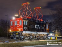 Repainted and Relighted. When former Canadian National Railway Company 6710 (Z-1a, General Electric, 1914) was retired from service in 1995, it was donated to the City of Deux Montagnes, Quebec, then the end of the Deux Montagnes Line. After sitting as a stationary display for a number of years, it became eroded by the elements. In 2019, it was moved to Parc Belair about a mile from that location. The locomotive was repainted and even the pantographs now reach upwards towards an invisible catenary again and the headlights and number board shine brightly at night, as seen on Monday, April 3, 2023. The line is currently closed while it is being reconfigured for light rail operation.