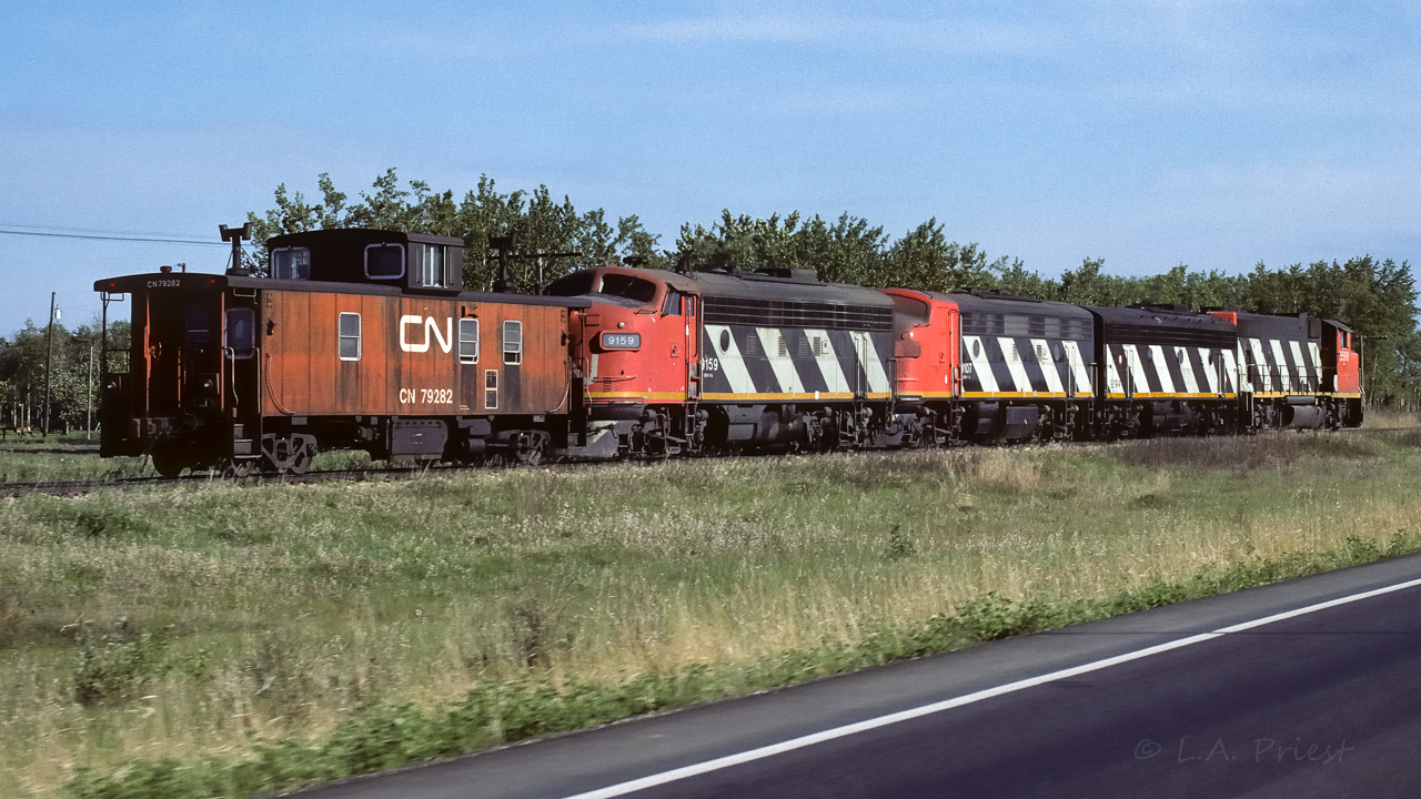 The chase is on in this photo. Grabbing a couple more shots of this consist before the highway crosses the tracks and the sun will be on the wrong side. Photo taken north of Egremont at 8:30.