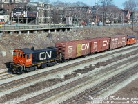 Just passing through Sunnyside: CN 8175, an MLW S7, heads westbound on the Oakville Sub through Sunnyside with a short local in tow. Two 40' boxcars follow: one an 8' door car (yellow doors signified newsprint service) the other a rebuilt 9' door car, plus a Southern 50' boxcar and one of CN's distinctive transfer cabooses. An eastbound TTC CLRV streetcar can be seen above on King Street West.<br><br><i>Michael Tedesco photo, Dan Dell'Unto collection slide.</i>