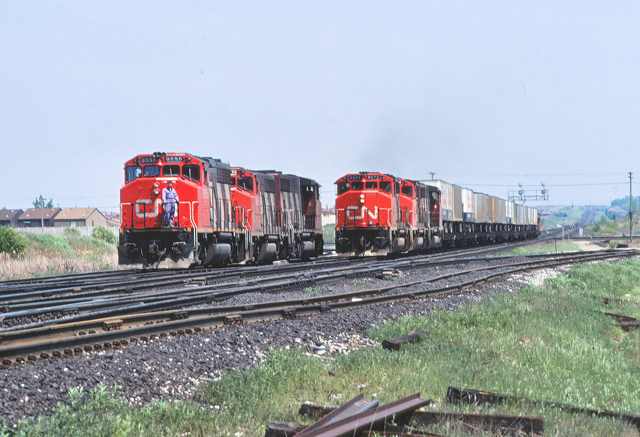 CN train 218 with 9573 leading has dropped off its head end cars into MacMillan Yard, backed out on to the York Sub and is now heading west with the "pigs" for the Brampton Intermodal Terminal. The 9555 on the left is actually the trailing unit of a consist that has just dropped off its train on the north connecting track to the Newmarket Sub siding at Snider and is returning to retrieve its caboose before heading to MacMillan Yard.

The comments on my earlier post got me to think of this image. Thanks everyone.