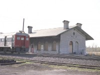 While stopped by the old Ernestwon station many years ago and getting a few pictures of the stone structure  there, I was rather hoping for some rail activity, but it was all quiet.  So I sat in the car for a minute, checking out my map ..... and suddenly heard a noise.  It was the Budds, I'll bet doing close to 80 MPH and I was not quick enough. This is all I could get, but it will have to do.  Camera was set at 500th/sec and still, the Budds are blurred.
I understand the station is still in situ, being designated a heritage building in 1994. The building, constructed around 1855, is similar to others at Port Hope, Prescott and St. Marys Jct.
Ernestown is mile 187.7 on the Kingston Sub, three miles east of Bath; the community it was originally built to serve.