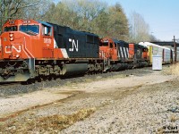 A CN westbound with CN SD75I 5619, SD40 5035 and SD40-2Q 6008 are viewed grinding to the top of the Dundas Subdivision grade at Copetown, Ontario during spring 1999. 