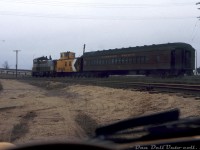 Viewed from the unknown photographer's seat of a yellow Opel GT during an April 1975 trip railfanning Canadian Pacific's Dominion Atlantic Railway, CP SW1200RS 8137 is in charge of today's Truro-Windsor mixed train #22, seen here at Windsor NS coupled to its wooden 437xxx-series van and steel heavyweight coach 1303. The mixed may have dropped their freight at the yard and possibly waiting to head to the station nearby.<br><br>Just like how the 8160-8162 were longtime assigned units on the GRR/LE&N, the 8130-series SW1200RS units were typical power assigned to the DAR, based out of Kentville NS for maintenance purposes but sometimes travelling to Montreal for major work. In later years, rebuilt 1200-series units would handle duties with other 8100's. <br><br>At the time of this photo, DAR ran a mixed train from Truro to Windsor (#22) in the morning, and back from Windsor to Truro (#21) in the afternoon. This was the last mixed train operating on Canadian Paccific, and was likely one of the last uses of heavywight coaches in revenue service on the system. Regularly assigned at this time was coach 1303, a heavyweight first class coach originally built in 1929. <br><br>In June coach 1303 would be replaced with another heavyweight coach in mixed service (1720, that was used until the mixed trains were cancelled in October 1979. It featured a refurbished interior with bus-style seats). 1303 was then donated to the National Museum of Science & Technology (becoming their "Micmac"), eventually going to the BC chapter of the NHRS out west, and has since been since sold to Heber Valley in the US, along with most of the organization's collection.<br><br><i>Original photographer unknown, Dan Dell'Unto collection slide.</i>