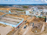 An overview the tight track layout at Dryden's Domtar Mill. Cando SW1200RS 1008 has completed its switch of the chemical plant and is in the process of running around two cars (1 caustic and 1 acid). The boxcars spotted up top are beside the former stud mill which rarely sees any cars spotted inside anymore. Down the hill in the background, you can make out a solo boxcar sitting on the track that leads to the pulp and paper shed, behind that is a string of boxcars in one of two tracks that are used for lifts and set offs. CPKC train number 420 can be seen accelerating from their earlier stop to drop off traffic for the mill. Further to the left a pair of tracks can be seen with a number of tank cars and sodium clorate hoppers, stored awaiting their spot. Both these tracks were originally used to load IMS containers. This mill use to pump out fine paper that would be loaded in containers and lifted by a 100 series freight (107/108 iirc). This traffic ended around the time of the 2008 recession. CP serviced this industry up until August 2014. This mill is currently up for sale, one of the many mills that is required to be sold after the Domtar's parent company, Paper Excellence's acquisition of Resolute Forest Products.