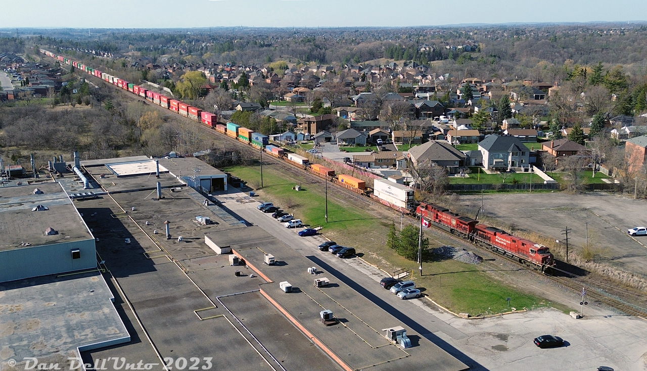 On the "Last Day of CP" for Canadian Pacific as its own corporate identity, before becoming part of the CPKC merger borg, it was the first day of dispatching the foam drone high over Woodbridge: CP 8857 and 9803 back their intermodal train up the MacTier Sub into Vaughan Intermodal Terminal, after having pulled ahead and stopped short of the crossing at Kipling Avenue in downtown Woodbridge.

The train is seen clearing the private crossing to Woodbridge Foam, a longtime local industry that began as Robinson Cotton Mills Ltd in the 1920's, before branching into urethane foam in the 1950's (for cushioning, furniture and automotive products) as Robinson Moulded Products Ltd and Robinson Foams Ltd. The plant, now Woodbridge Foam Ltd, is still active here, with a branch in Kitchener as well.

(Special thanks to the young couple who volunteered a spare a water bottle on this warm day, after an unfortunate non-drone, non-rail related transportation occurance).