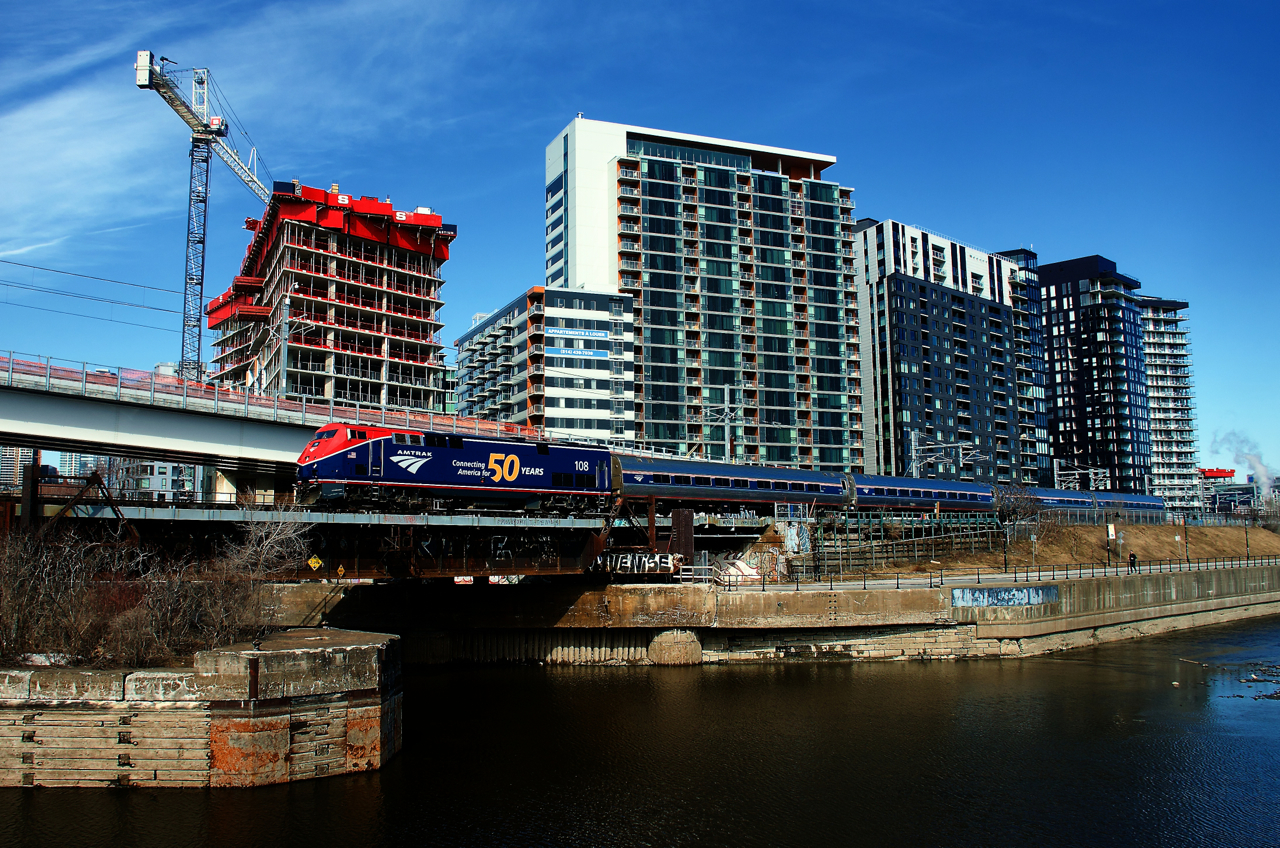 The first southbound Adirondack in over three years is passing the Peel Basin five minutes after its departure from Central Station in Montreal. 50th anniversary unit Amtk 108 is leading.