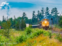 Having dropped a flatcar (presumably to load some new culverts) at the back track in Temagami, Englehart bound freight 113 is back up to track speed with their respectable sized freight and six locomotives 2104-1805-PRLX 2270-2101-2102-2105. Storm clouds are building and by the time the train reaches Englehart, the crew will have to yard their train under threat of Tornado Warnings.