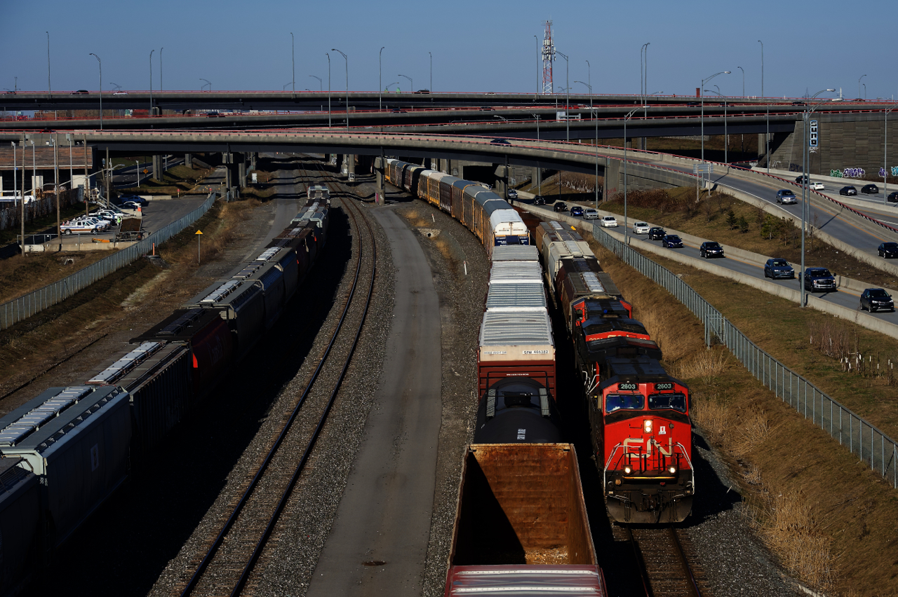 A tank car on CN 400 at left allows enough room to get a non-shadowed shot of CN 321's leader as the two trains meet. At far left grain cars are parked on Track 29.