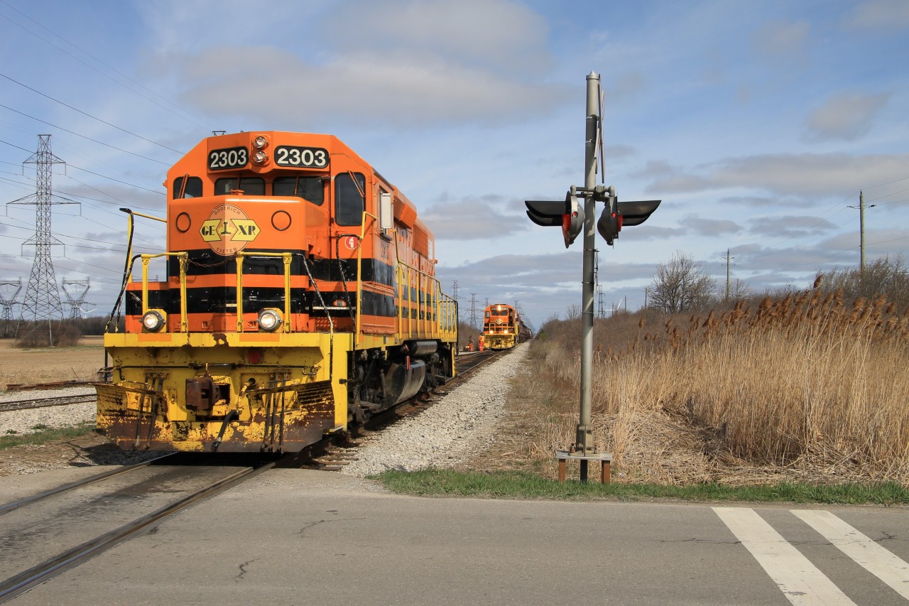 GEXR 2303 (Texaco Job) is sitting south of the junction switch with the Stelco Spur. The Garnet Yard Job with QGRY 2301 and RLK 4095 trailing blocks of coil cars and tanks is stopped north of the junction switch, after a job briefing they will pull south onto the Stelco Spur, cut off the tail end block of tanks just north of the switch and then continue south to Stelco. GEXR 2303 will couple onto the tanks and after getting their air will head south on the Hydro Spur to switch Texaco.