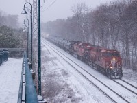 January 25th, 2023 was the first major snowstorm of 2023. The first real snow in nearly a month so I made it a priority to get trackside. Here's CP 230 passing the Summerhill pedestrian bridge as the snow starts to accumulate on the surrounding trees. A pair of CP GEs pull this one (CP 8904 & CP 8034) but that's just about standard at this point. 