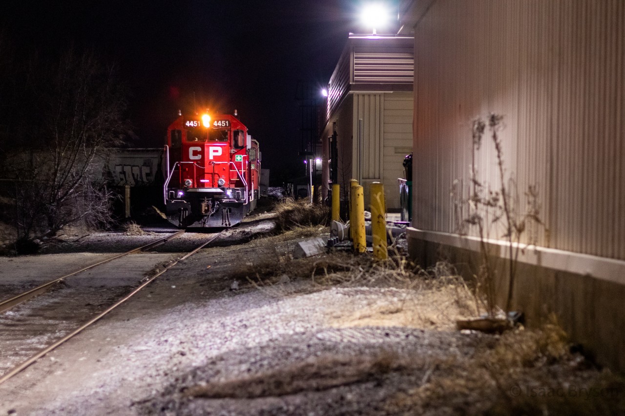 The CP Agincourt yard East job is doing some midnight switching along a spur just north of Toronto yard. They are drilling the Owen's Corning fiberglass industry and would end up taking 5 hoppers out of the small yard back to Agincourt. I don't think the crew was too pleased to have some foamers running around at 1am but we tried our best to keep them out of our photographs. CP 4451 & CP 3033 provide the power. 
The spur name in the description is a guess, a general description of the area.
