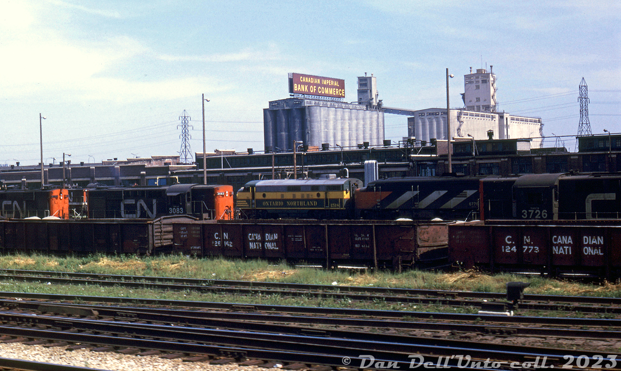 A nice selection of power lays over at CN's Spadina Roundhouse locomotive servicing tracks in downtown Toronto. Visible in the middle is Ontario Northland FP7 1518 (a regular visitor to Spadina Roundhouse off the "Northland" ONR-CN pooled passenger train) coupled to CN FPA4 6776, its likely running mate. RS18's 3726 and 3123 bracket RS10 3083 (whose short hood ended up as a spare at Moncton NB shops by 1975, after the 244-fleet was retired). A CN 1900-series GMD-1 is also visible in the distance. 

In the foreground are some CN "GS" bottom-dump gondolas. In the background, the old Maple Leaf Mills elevators on the harbourfront (opened in 1928 as Toronto Elevators Ltd with a 2 million bushel capacity, demolished in 1982-83. The VIA-CN Spadina facilities would follow a similar fate a few years later).

Original photographer unknown, Dan Dell'Unto collection slide.