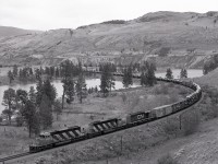 A former oxbow of the Thompson River near Walhachin provided abundant photographic opportunities, with CN down close to river level compared to CP who climbed high above, their Thompson sub. visible in the distance.  CN 5289 + 5286 + 5126 westward appeared at 1236 PDT on Saturday 1980-05-24, and passed milepost 30 shown on the far right shortly before arriving at the east siding switch at Walhachin.