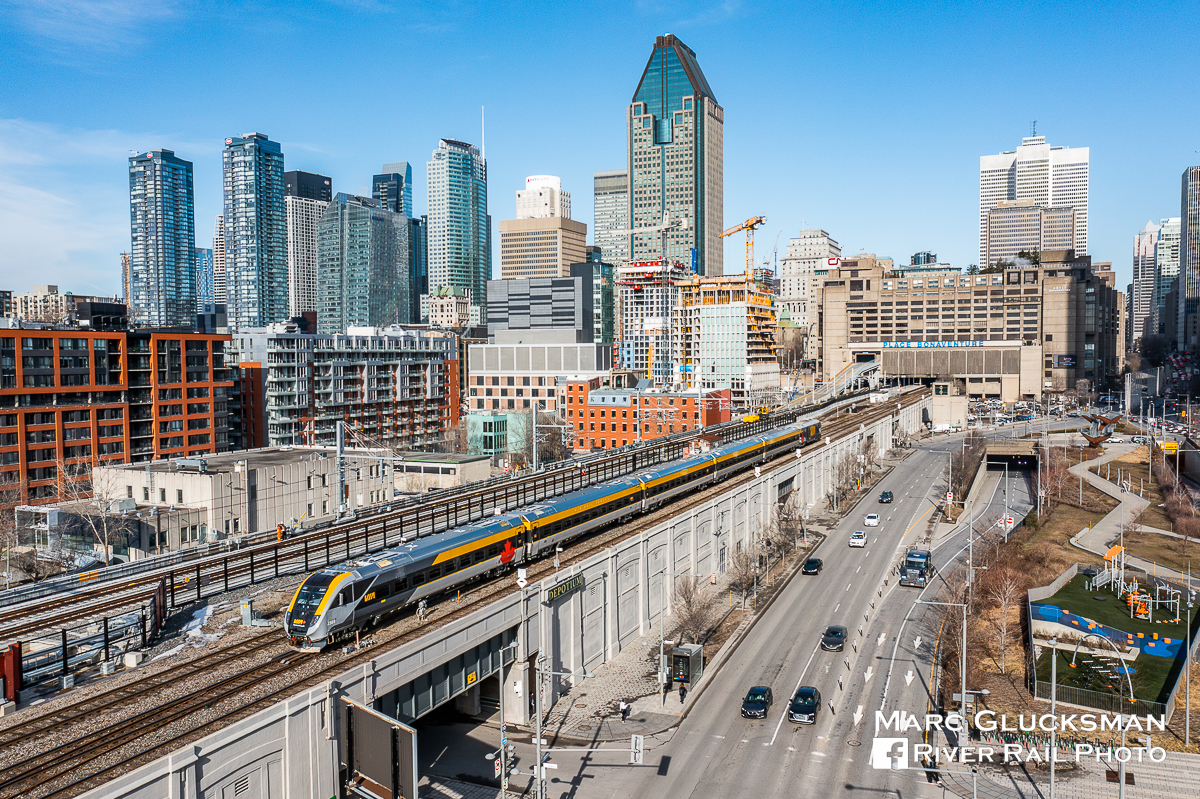 The New Look Of VIA. On the morning of April 4, 2023, VIA Rail Canada Train 33 (Quebec City, QC-Ottawa, ON) was assigned a Siemens Venture train set, seen being led by Cab Car SIIX 2301 (consist: coaches 2901, 2801, 2701, 2601 and locomotive SCV-42 2202) as it departs Gare Central in Montreal, Quebec. VIA has ordered 32 of these train sets to equip its inter-city fleet. The tracks to the left of frame show the ongoing construction for the new REM (Réseau express métropolitain or Metropolitan Express Network) a fully automated light rail system that will significantly change the transit options in the Montreal area.