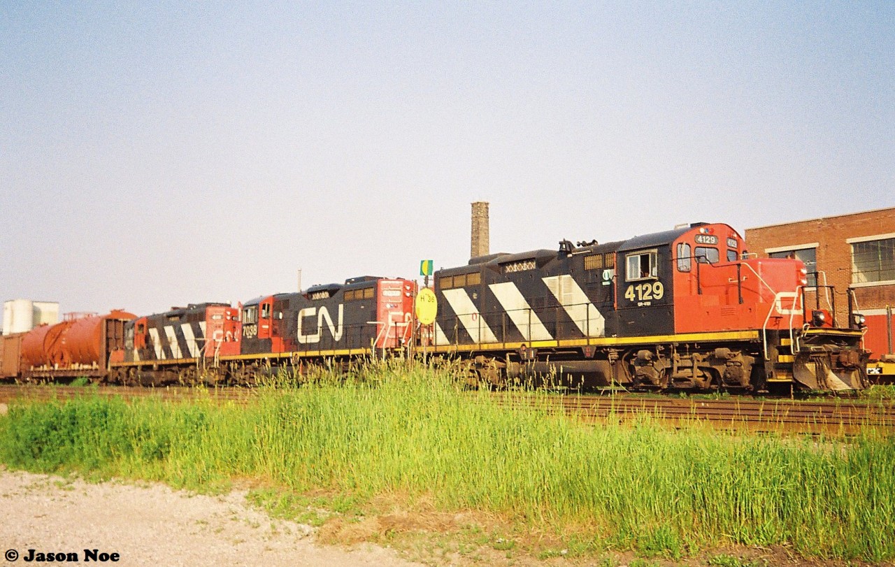 CN 421 is pictured at the Kitchener yard with a trio of GP9RM’s on a summer evening that includes; 4129, 7038 and 4111. The car immediately behind the power possibly came from Babcock & Wilcox on the Fergus Spur in Cambridge. During the summer of 1993, solid sets of GP9RM’s would often power 421 from MacMillan Yard in Toronto.