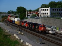 CN 120 has two geeps and an inspection boxcar trailing behind the road power as it passes a foreman. Unit numbers are CN 3080, CN 3845, CN 9410, CN 4789 & CNIS 412040.