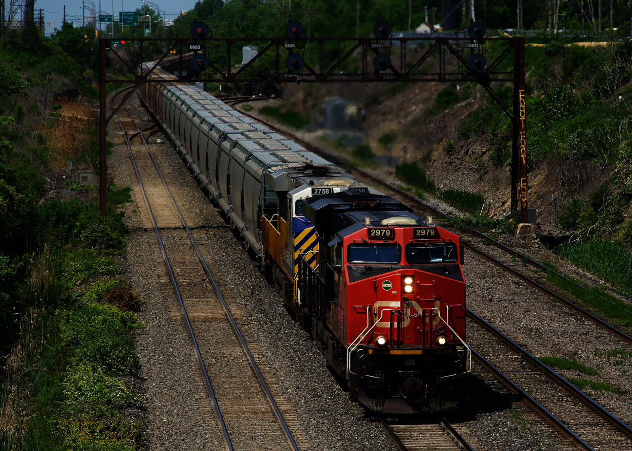 After parking nearby overnight, loaded potash train CN B730 is on the move with a pair of ES44ACs up front.