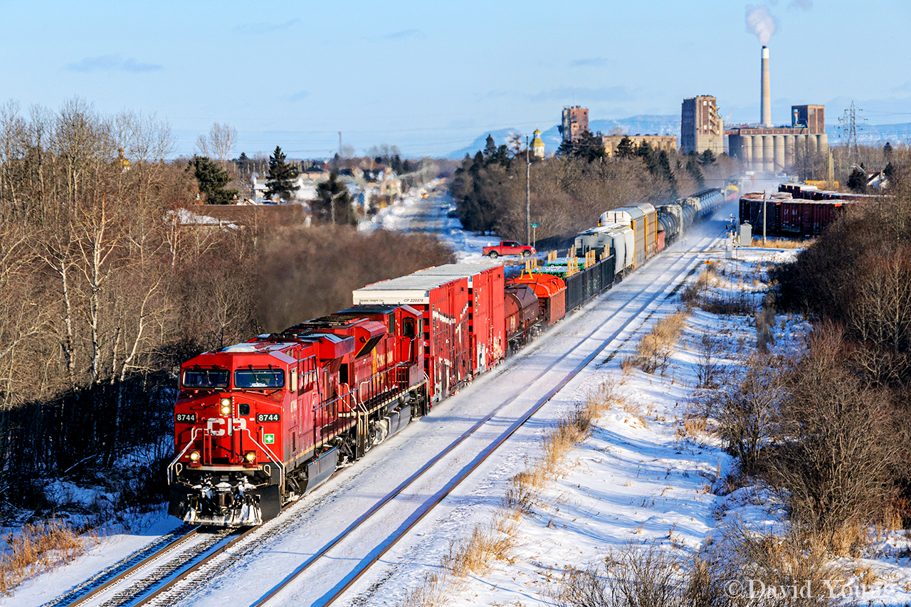 Accelerating out of Thunder Bay, the era's "Switcher" rolls over Neebing Ave westbound with work at locations like Dryden, Vermilion Bay, Trus Joist and Kenora. 

A number of things here have changed in the years since this shot. 

First off, the SD90Mac trailing disappeared the year after this photo was taken- only to languish for about decade before being rebuilt into an SD70ACu. The "farm leads" loaded with boxcars for the local paper mill were taken our of service and the tracks removed in the coming years, while the smoke stack from the local OPG plant puffing away here, came down sometime in 2021. Progress.....