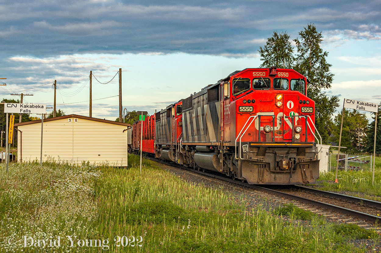 Thunder Bay to Fort Frances freight CN 437 is making good time through the small town of Kakabeka Falls with a duo of veteran cowls in the lead. Passing the razed station site of the station, replaced with a mundane shack used for MoW employees decked out in that lovely beige siding. The double station name signs framing both sides of the main herald  back to better times with this section of right of way was double tracked. For those keeping track power was behind the lead SD60F was sister CN 5533. Behind them, a pulp car destined for pulp load out at the back track at Annex.